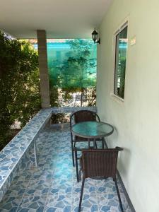 罗勇MaihomSailom Resort的庭院设有两把椅子、一张桌子和一扇窗户。
