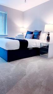 卢顿Foundry luxury new one bedroom apartments close to town center的一间卧室配有一张带蓝色枕头的大床