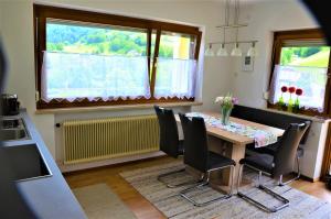 FrastanzFerienwohnung Walgaublick的一间带桌椅和窗户的用餐室