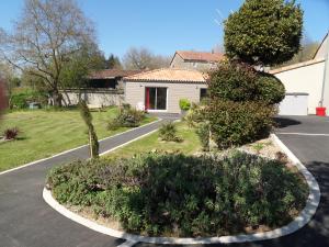 莱瑟佩瑟Au Petit Bignon的车道,房子,种植植物的院子