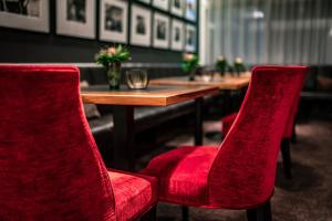 巴特绍尔高Romantik Hotel Kleber Post的一张桌子,上面有两把红色的椅子和一张木桌,西德西德