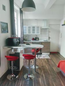 马赛La Maison de Valentino的厨房里设有柜台和红色凳子