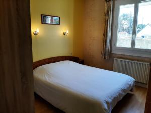 圣皮耶尔基贝龙Home des Pins SARL的卧室配有白色的床和窗户。