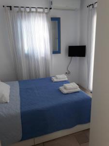 普恩达S＆K 麦松奈特斯酒店的一间卧室配有蓝色的床和2条毛巾