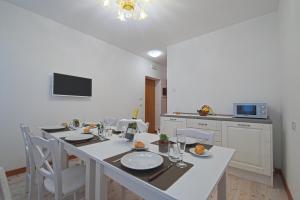 威尼斯Palazzetto Canossa的一间配备有白色桌椅的用餐室
