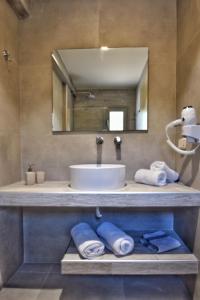 特拉佩扎奇Liogerma Studios的浴室配有盥洗盆、镜子和毛巾