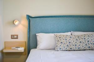 特拉佩扎奇Liogerma Studios的一张带蓝色床头板、枕头和灯的床