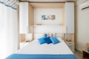 圣贝内代托-德尔特龙托Mavip Residence的一间卧室配有白色床和蓝色枕头