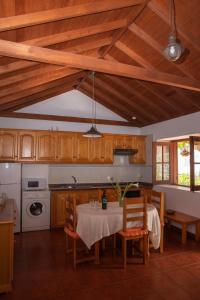 埃尔米瓜Casa Rural Nuevitas I的厨房配有桌椅和木制橱柜。