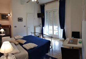 利多迪卡马约雷乐米迪维西里亚旅馆的一间卧室配有蓝色的床、一张桌子和一个窗户。