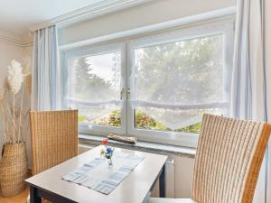 维斯马Comfortable Apartment in Wismar near the Baltic Sea的一间带桌子和两把椅子的用餐室以及窗户。