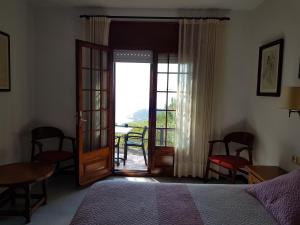 巴古尔Hostal Sa Barraca - Adults Only的一间卧室设有一张床,并有通往阳台的门