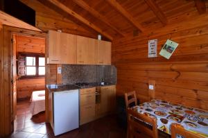 La Rasa SelorioCamping Villaviciosa的小屋内的厨房配有冰箱和桌子