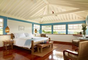 安帕鲁Lake Vilas Charm Hotel的一间卧室设有一张大床,拥有蓝色的墙壁和窗户。