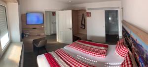 普尔海姆Abtei Apartment Brauweiler的一间卧室配有一张带红白毯子的床