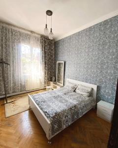 巴统Eka Guest House的壁纸客房内的一间卧室配有一张床