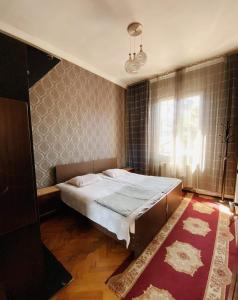 巴统Eka Guest House的一间卧室设有一张大床和一个窗户。