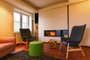 库罗阿尔滕堡Berghaus Falkenhorst的客厅配有三把椅子和壁炉