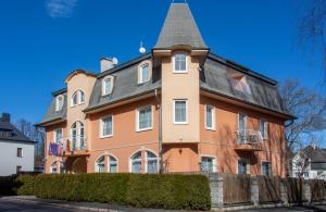 玛丽亚温泉Villa Anzio的一座大型橙色房子,屋顶灰灰色