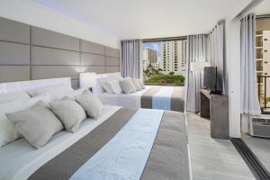 檀香山Waikiki Banyan Modern One Bedroom Free Parking的酒店客房设有两张床和电视。