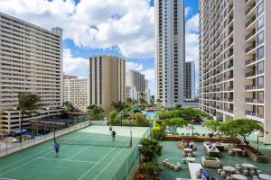 檀香山Waikiki Banyan Modern One Bedroom Free Parking的两人在城市的网球场打网球