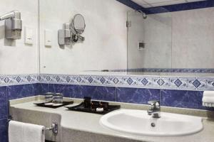 马斯喀特库隆海滩华美达酒店的一间带水槽和镜子的浴室