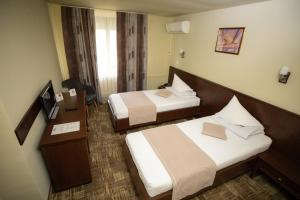 斯洛博齐亚Hotel Select Slobozia的酒店客房设有两张床和电视。