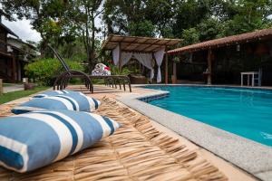 托兰克索Trancoso Pousada的游泳池旁设有枕头和长凳