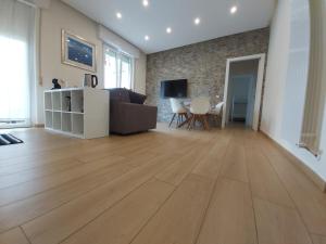 代森扎诺-德尔加达Le Rive的客厅铺有木地板,配有沙发。