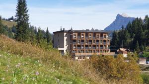 阿拉巴Hotel Boè Sport and Nature的山丘上的建筑,背景是山