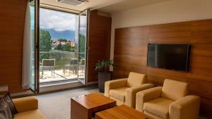 波普拉德Hotel AquaCity Mountain View的一间设有两把椅子和一台平面电视的房间