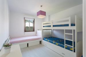 米尼奥Housingcoruña Apartamento Playa Miño 03的一间卧室设有两张双层床和一扇窗户。