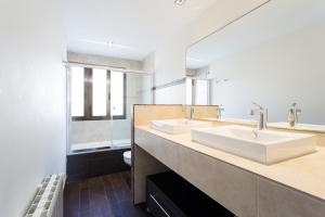 米尼奥Housingcoruña Apartamento Playa Miño 03的一间带两个盥洗盆和大镜子的浴室