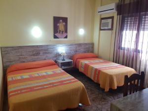 隆达圣女罗西奥旅馆的酒店客房设有两张床和一张桌子。