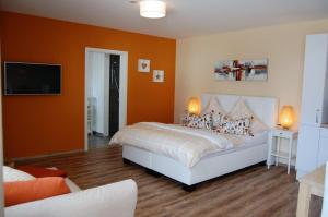 多瑙河畔迪林根Apart Hotel - Dillinger Schwabennest的一间卧室配有一张橙色墙壁的床