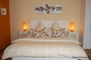多瑙河畔迪林根Apart Hotel - Dillinger Schwabennest的一间卧室配有一张带两盏灯的大型白色床。