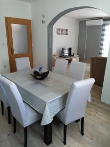 希贝尼克Apartment Darinka的餐桌、白色椅子和桌布