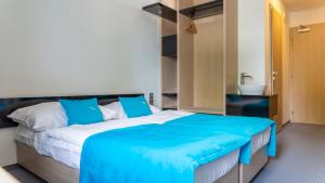 波普拉德水城滨江酒店的一间卧室配有一张带蓝色毯子的大床