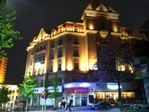 青岛青岛华奇凯帝酒店 的一座大建筑在晚上点燃