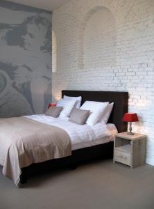 哈瑟尔特库切游玩住宿加早餐旅馆的一间卧室设有一张大床和砖墙