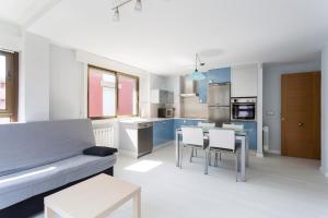 米尼奥Housingcoruña Apartamento Playa Miño 04的厨房配有沙发和桌椅