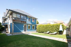 米尼奥Housingcoruña Apartamento Playa Miño 01的蓝色房子,带绿色庭院