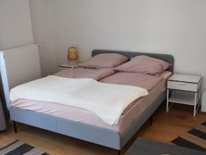 科隆DOM APARTS的一张带粉色和白色床单的床和一张边桌