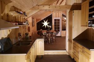 莱旺厄尔Unik fjøsleilighet的一间带木制橱柜的厨房和一间带桌子的用餐室