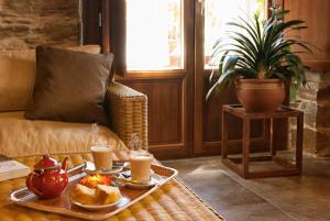 San Esteban de Valdueza锡伦西奥山谷酒店的咖啡桌,有两盘食物和两杯咖啡