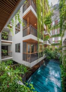 岘港Ponte Boutique Da Nang的植物繁茂的建筑中间的室内游泳池
