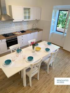 伊穆尼Stone & Salt Getaway Home的厨房配有白色桌子和蓝色餐具