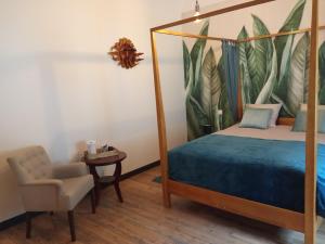 Varvinayla maison de Valbois的一间卧室配有一张天蓬床和一把椅子