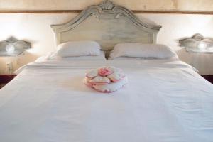 巴塞罗那巴塞罗那住宿艺术宾馆的白色床上的粉红色玫瑰,有两盏灯