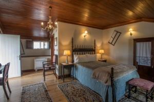 洛萨金塔尔德阿莱姆杜里贝罗-特里士姆乡村酒店的一间卧室设有一张床和木制天花板